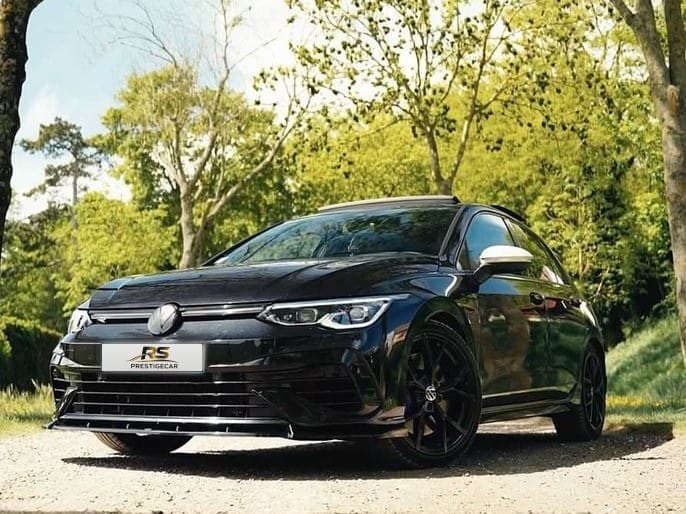 Volkswagen Golf 8 R noire de RS Prestige Car, vue avant trois-quarts sous les arbres